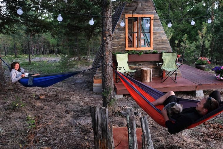 people in hammocks by a cabin