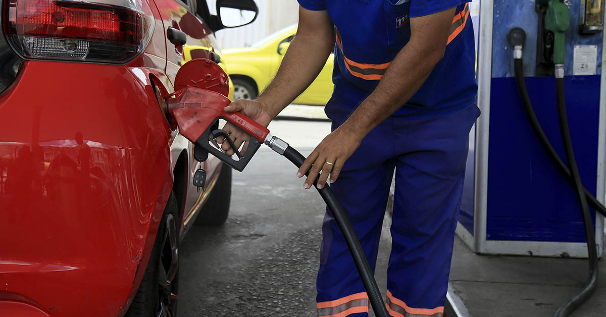 gas attendant filling a car with gasoline