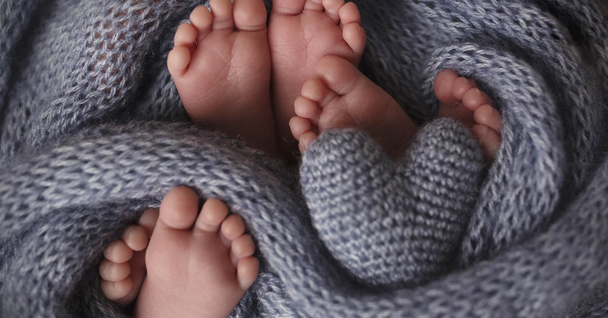 feet of infants wrapped in wool knitted blanket