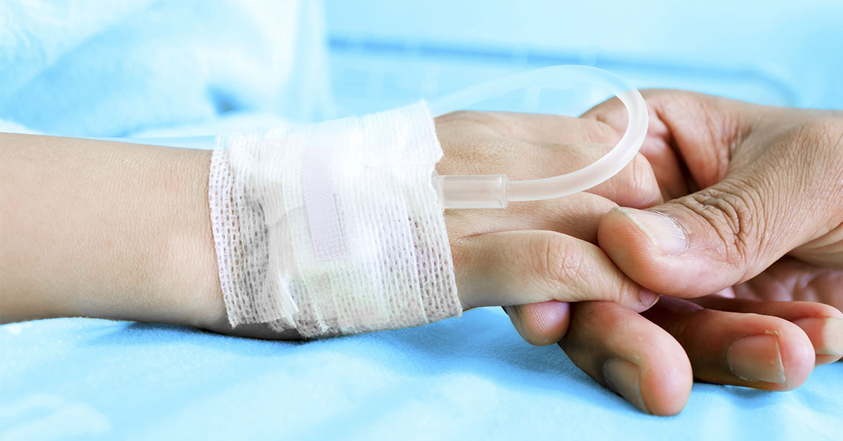 patients hand with IV being held