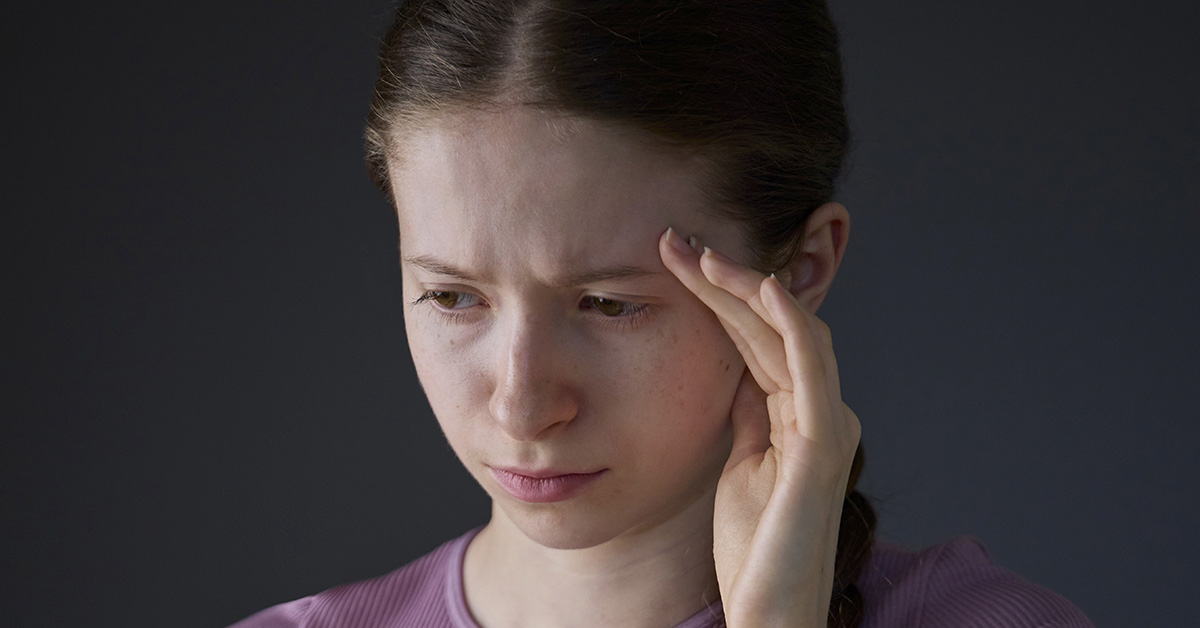 woman emotionally distraught with hand placed on forehead