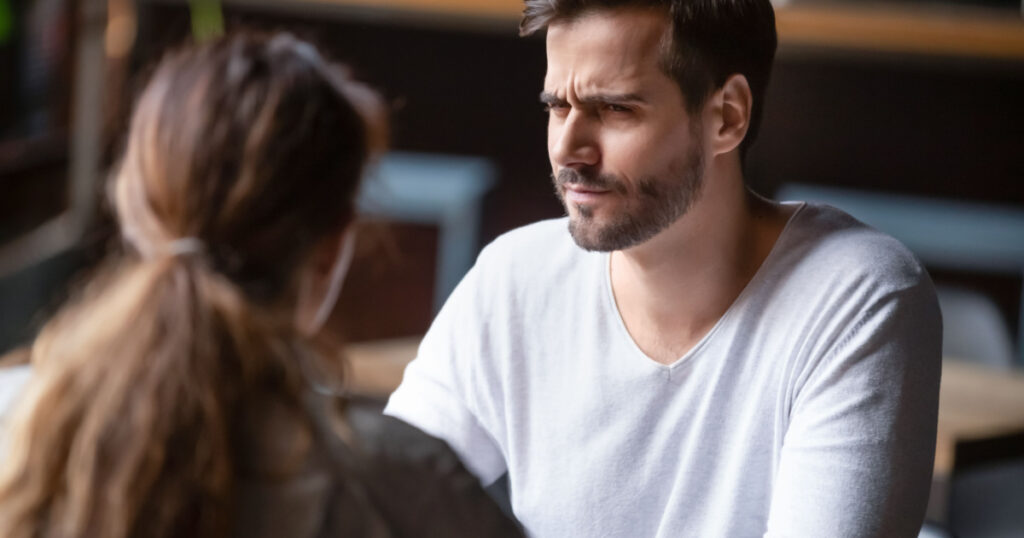 Doubting dissatisfied man looking at woman