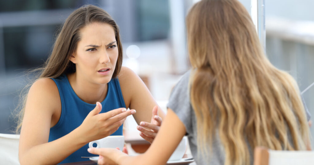 Upset woman talkign to narcissist  friend in coffee shop