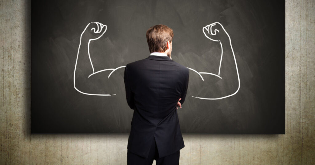 strong businessman standing in front of a chalkboard