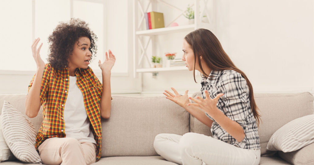 friends sitting on sofa arguing and shouting