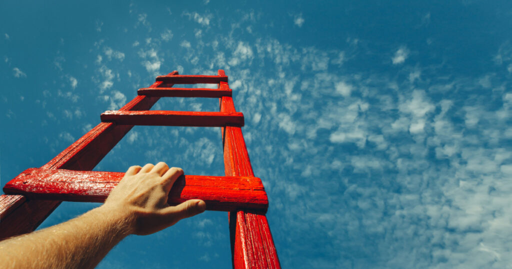 Development Attainment Motivation Career Growth Concept. Mans Hand Reaching For Red Ladder Leading To A Blue Sky
