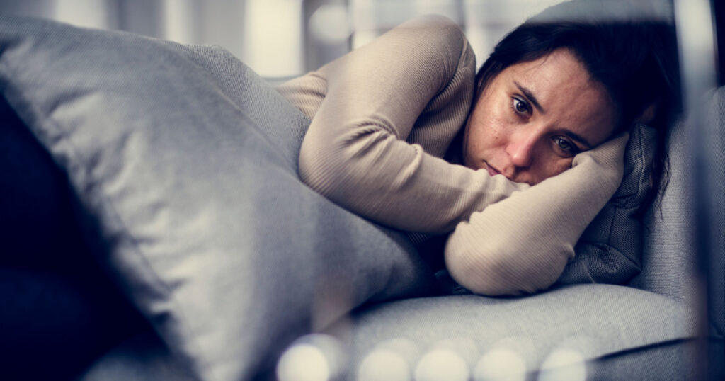 Depressed woman lying on the bed
