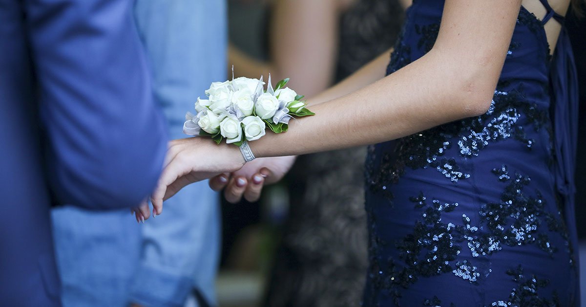teen girls arm with a white flower corsage