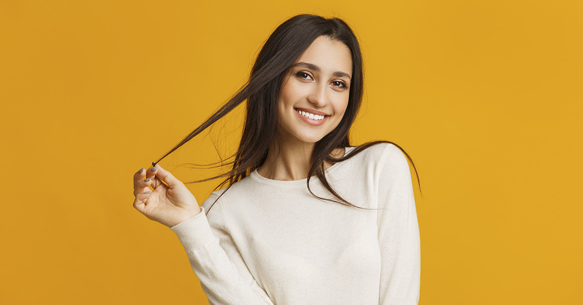 woman playing with hair. Orange background