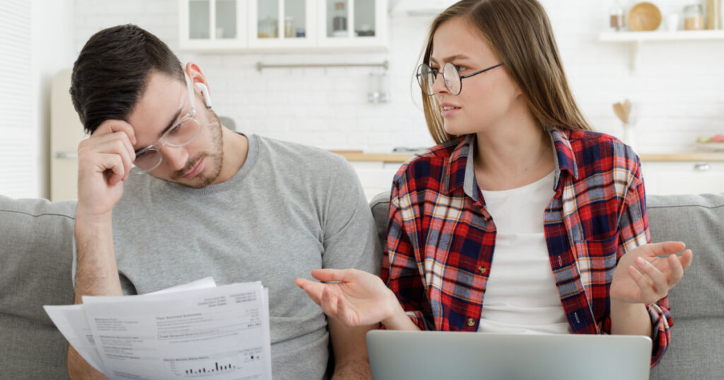 Family with no money. Young couple trying to pay bills online, having financial problems, worried about troubles with mortgage payment to bank and high taxes
