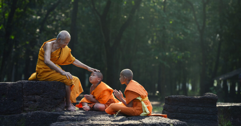Old Monk are teach little monks of buddhist and spiritual ancient buddha on the laterite in the forest
