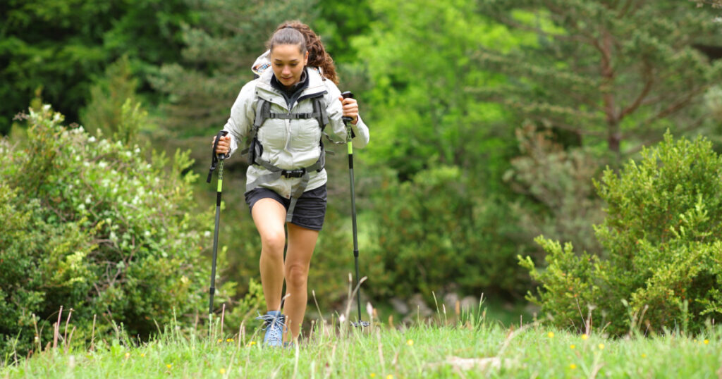 Front view portrait of a hiker walking towards you in a forest
