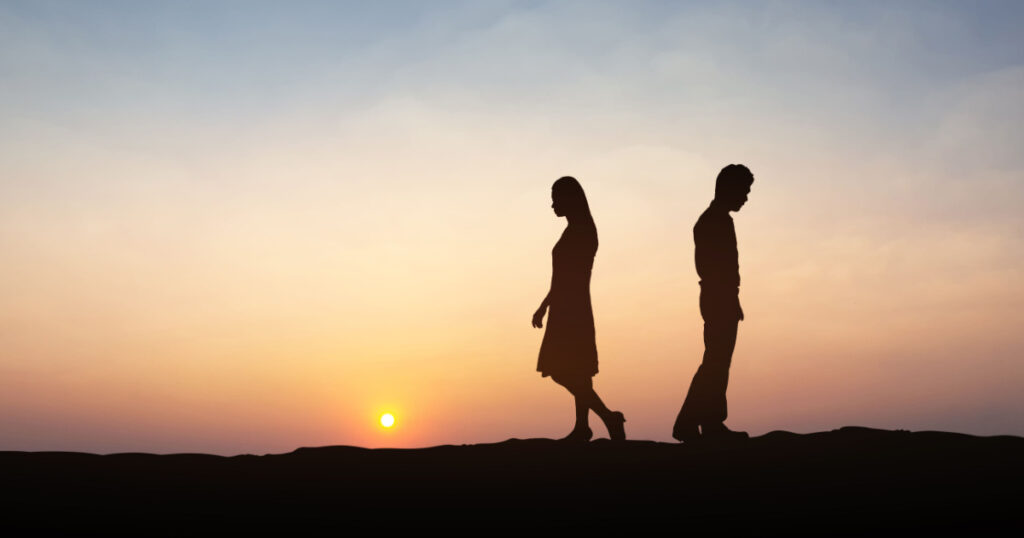 Silhouettes of couple man and woman broken heart. In nature sunset. Love concept.
