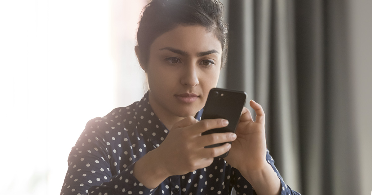 woman looking at/ using smartphone