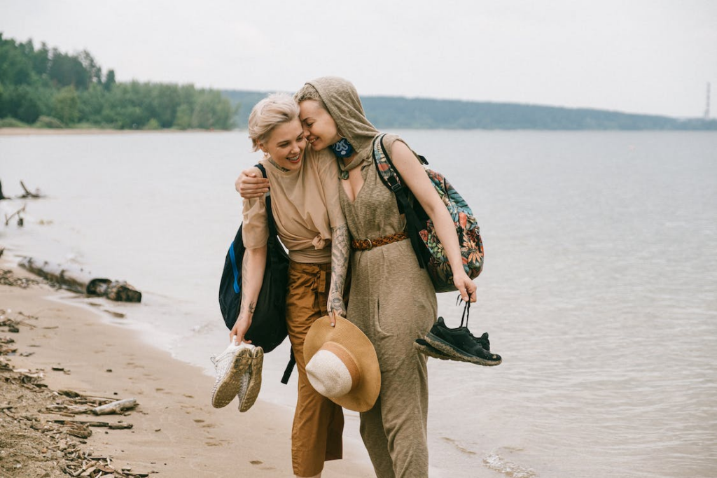 Photo of Women Embracing While Standing on Beach
