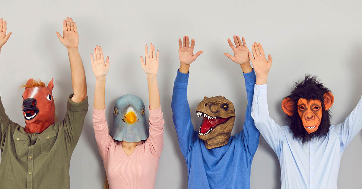 people wearing masks that resemble animals with their hands up in the air
