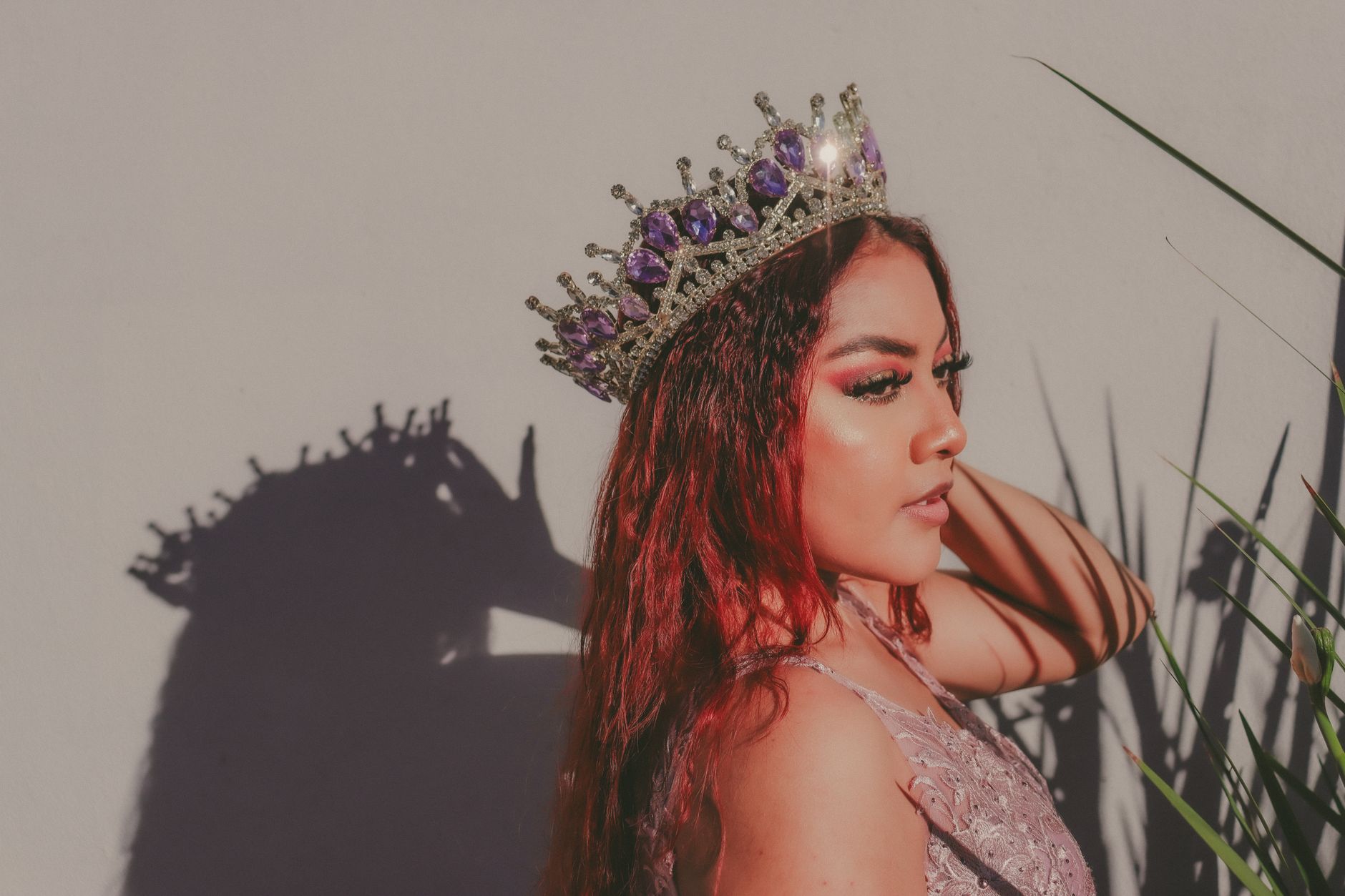 Artistic portrait of a woman with a crown, casting a dramatic shadow.