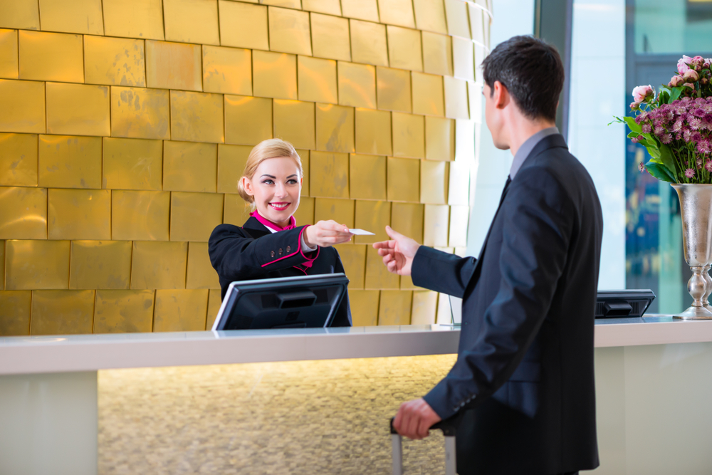 man checking in to hotel at front desk