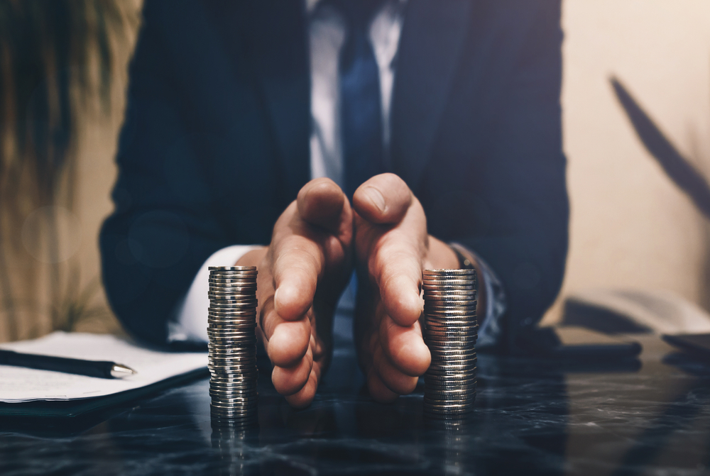 Businessman separates stack coins. Concept of saving and investing. Property division. Divorce and legal services.