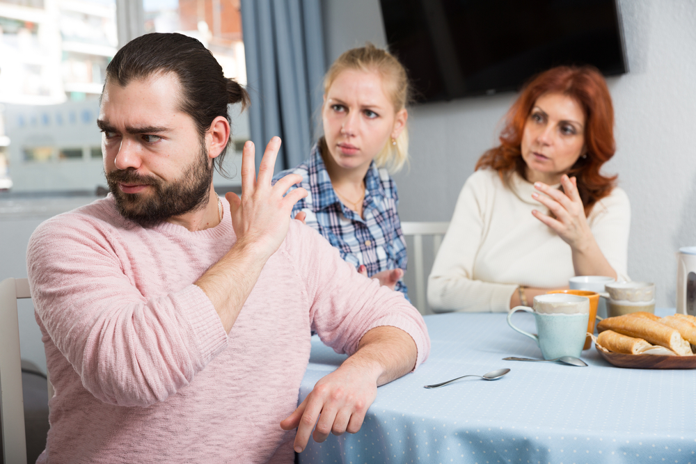 upset man arguing with women at table