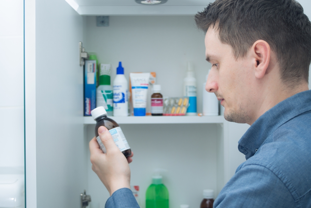man holding bottle of medicine