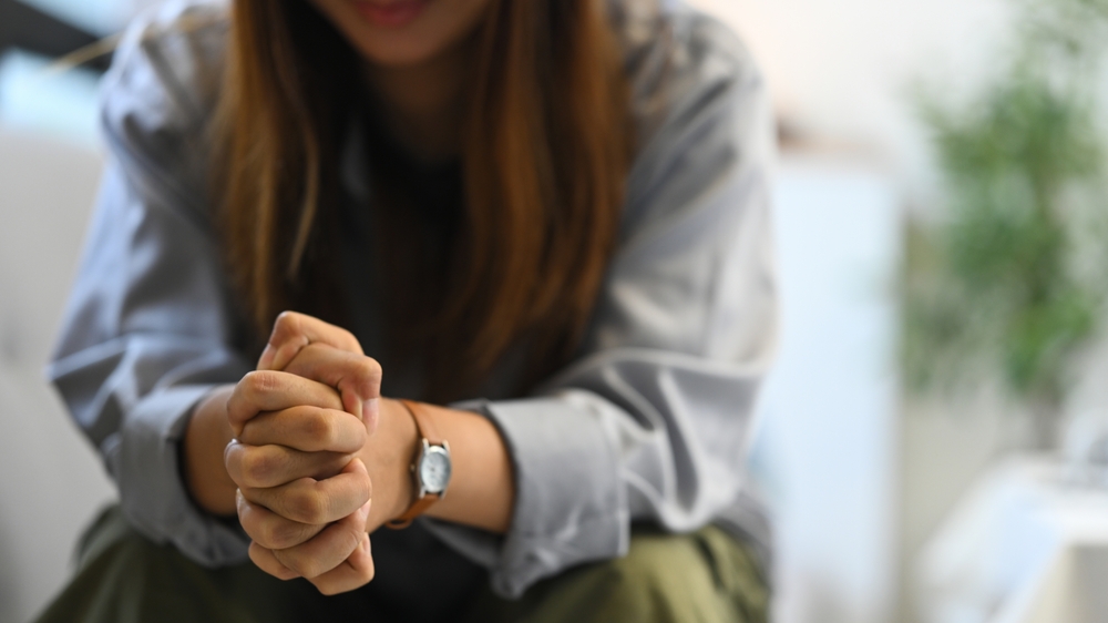 woman sitting with hands clasped
