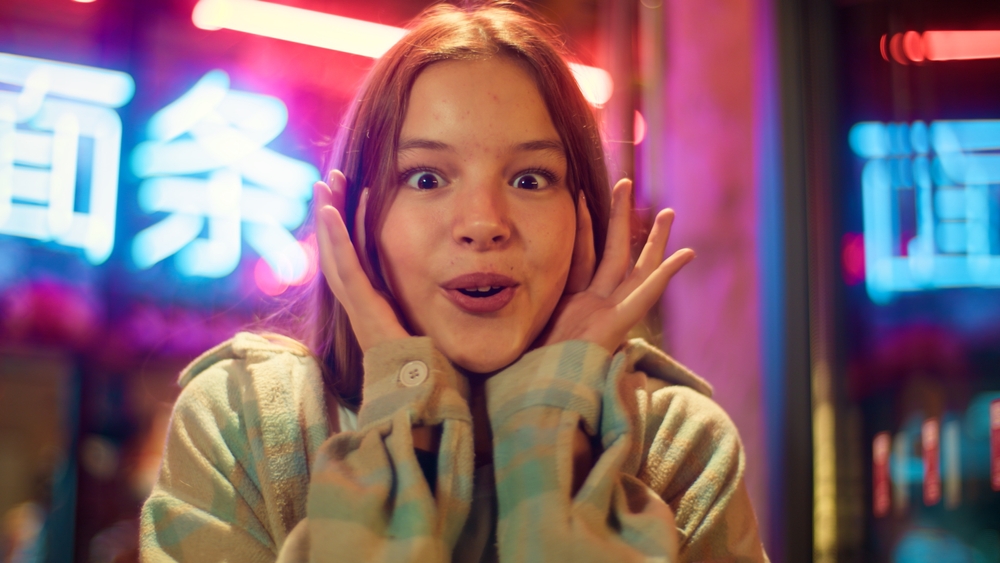 Portrait surprised Asian Caucasian daughter junior kid saying wow winning disbelief in city excited emotion shocked child teenager hear awesome news girl success win schoolgirl achievement night neon