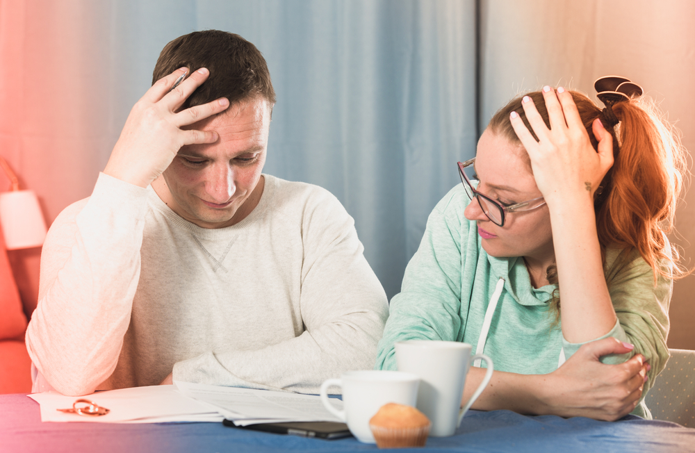couple looking at delinquent bills
