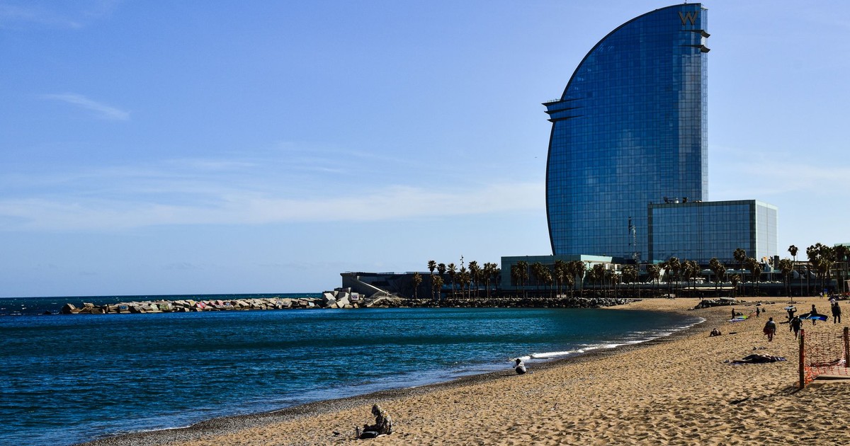 View of Barcelona beach with the iconic W Hotel and clear blue sky.