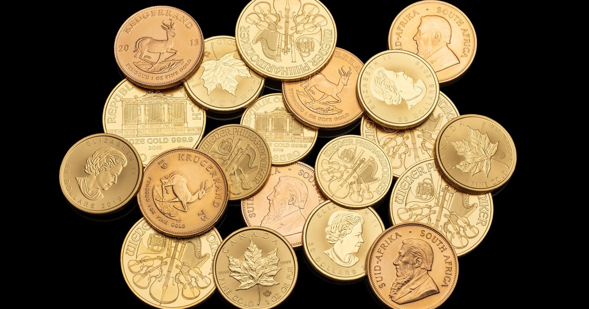 Assorted gold coins showcasing different currencies and designs isolated on a black background.
