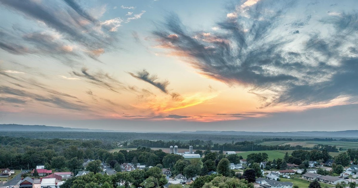 A picturesque aerial view of Nelson, Wisconsin, with colorful skies at sunset and lush greenery.