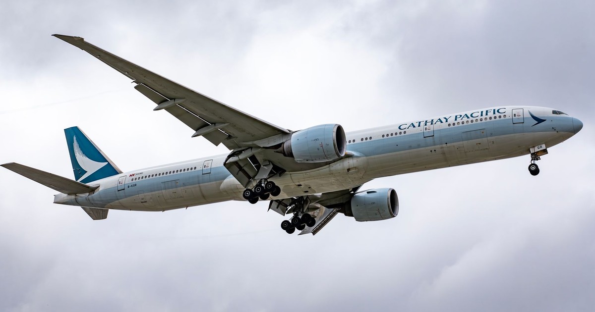 Cathay Pacific aircraft landing at Los Angeles International Airport under cloudy skies.