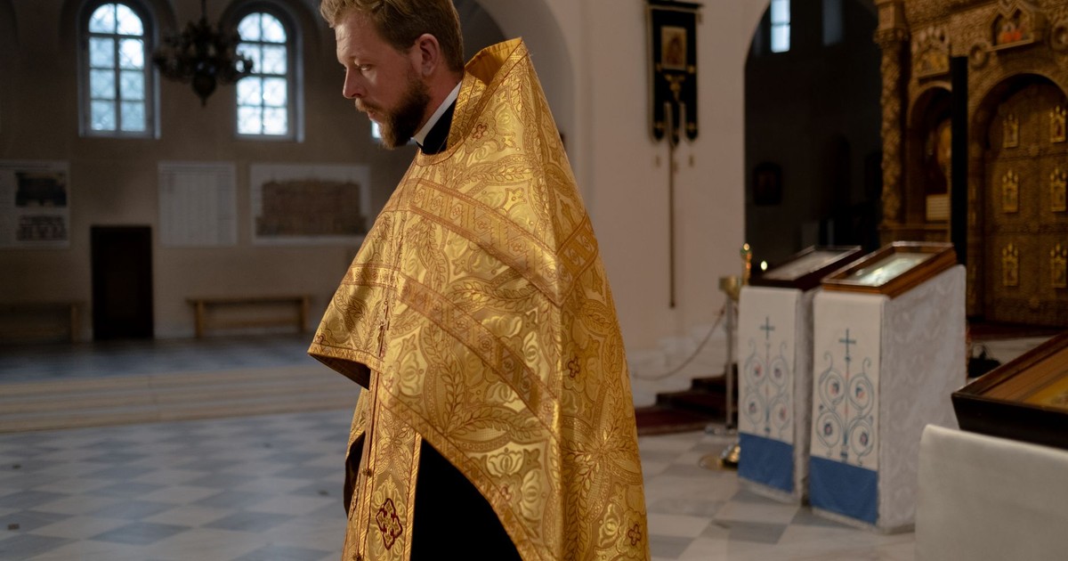 A serene scene of an orthodox priest inside a beautifully decorated church.