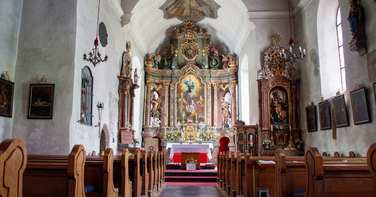A beautiful view of a historical church interior showcasing intricate altarpiece and wooden pews.