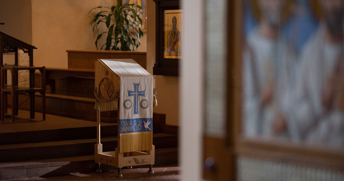 A serene lectern with religious icons in a beautifully decorated Orthodox church interior.