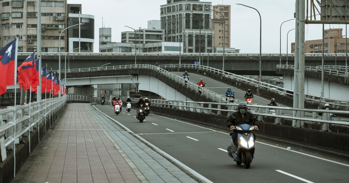 City scene showcasing scooters on a viaduct with urban buildings in the background.