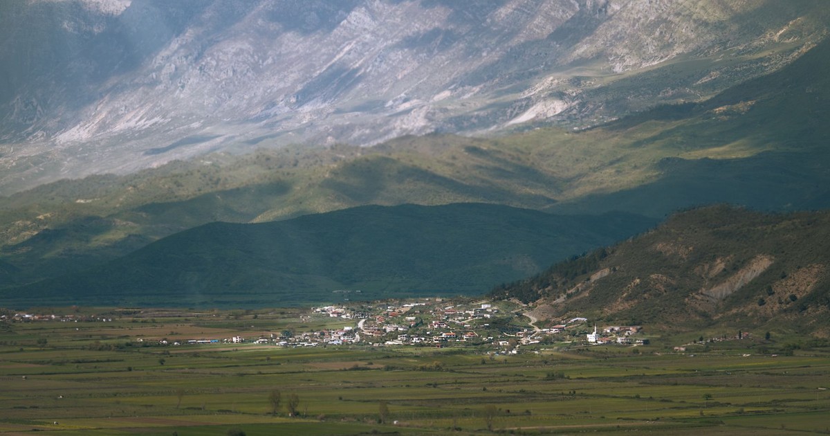 Beautiful view of an Albanian valley with a quaint village and majestic mountains in the background.