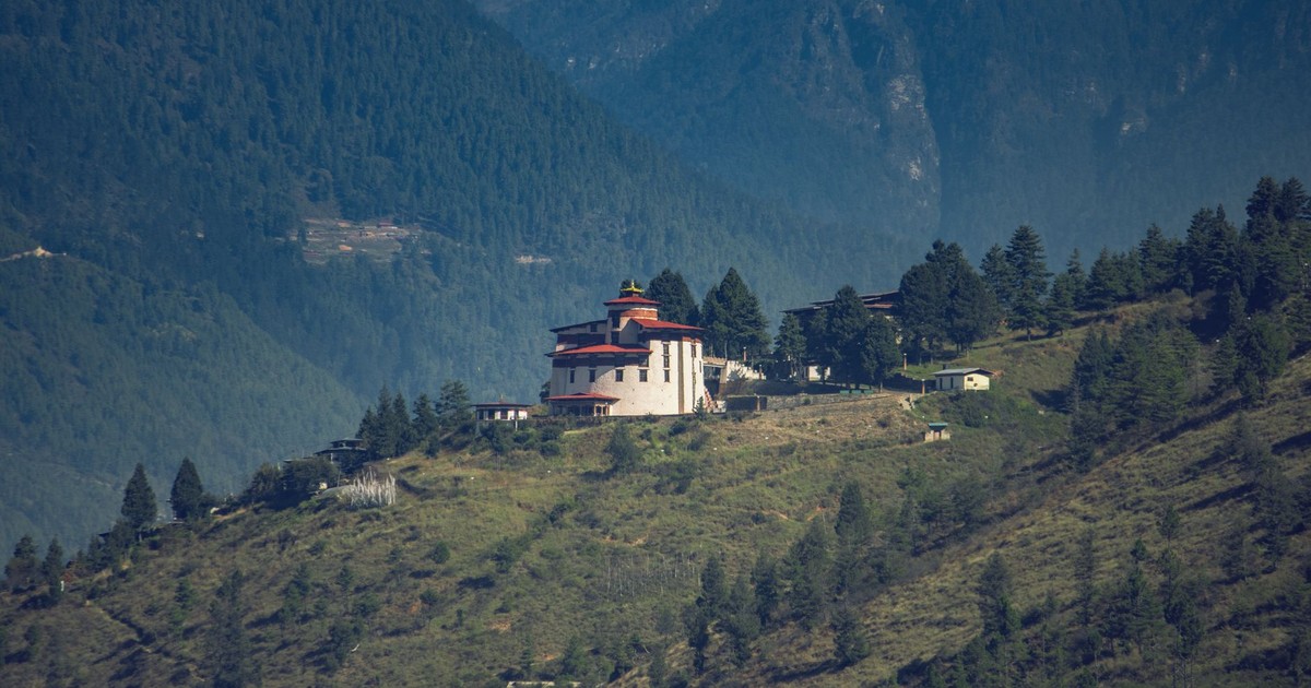 A distant view of Paro Taktsang Monastery nestled in the lush mountains of Bhutan.