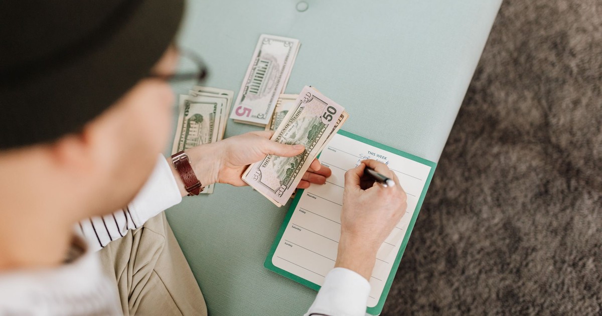 Individual budgeting with US dollars and a planner, focusing on financial planning.
