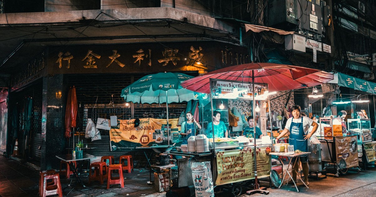 Vibrant night market scene in Bangkok showcasing street food vendors and bustling activity.