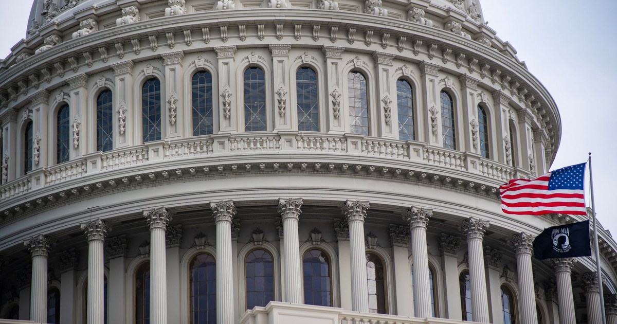 Detailed view of the US Capitol dome with the American flag flying nearby in Washington D.C.