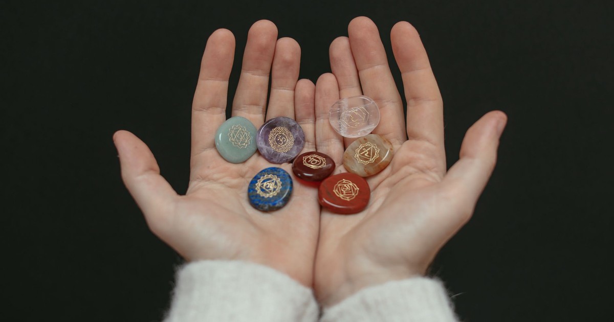 A close-up image of chakra stones held in open hands, showcasing spiritual balance.