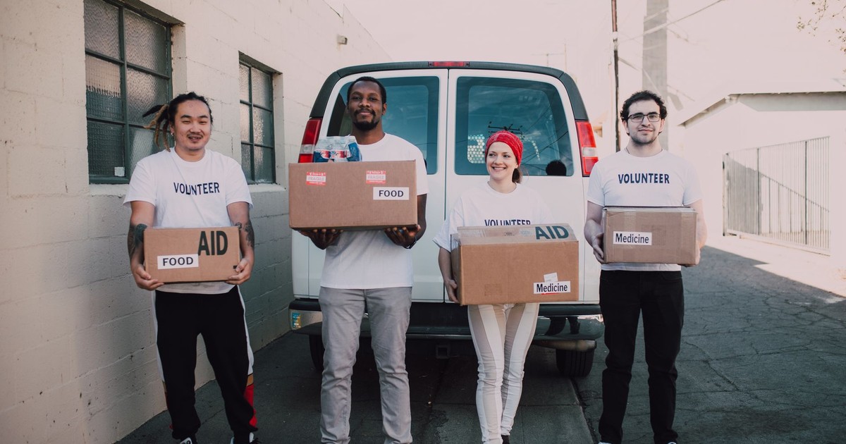 Group of volunteers holding aid boxes, ready to distribute in the community.