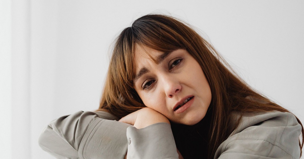 Close-up of a woman expressing sadness and emotional distress indoors.