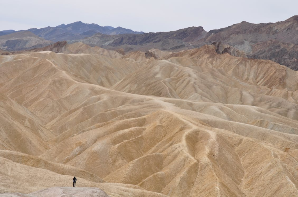 A breathtaking aerial shot of Death Valley's arid desert landscape with rugged terrain and distant mountains