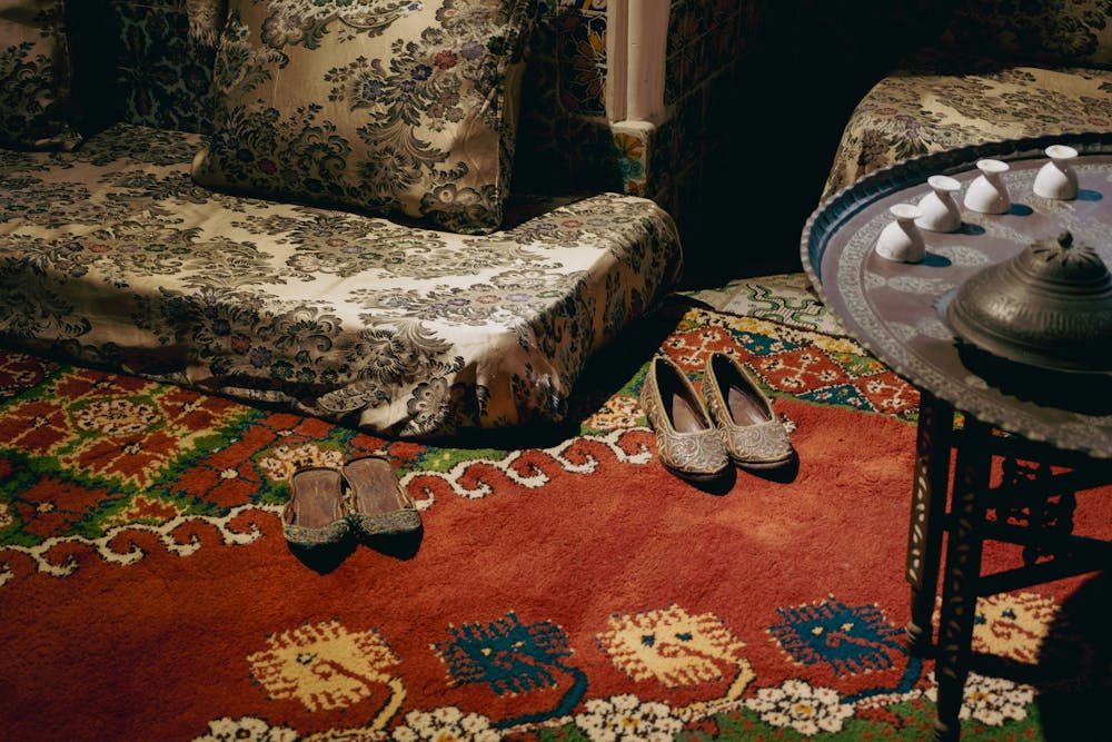 Cozy Turkish interior featuring a vibrant handmade carpet and traditional shoes, creating a vintage ambiance.