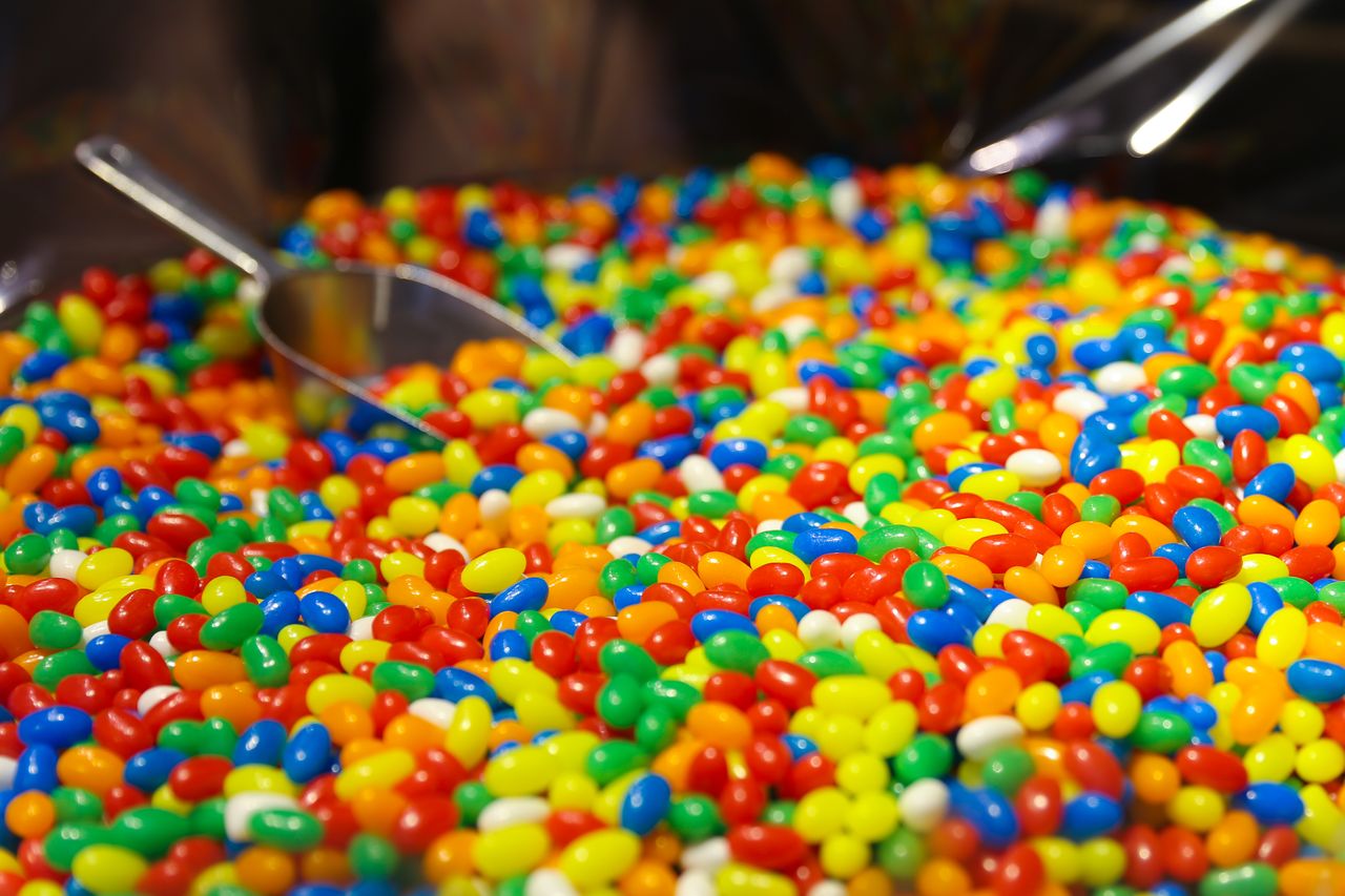 Vibrant selection of colorful jelly beans with a scoop at a candy store, bursting with sweetness