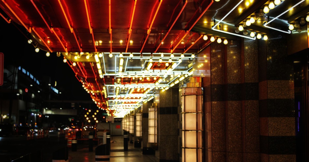 Bright neon lights illuminate a Las Vegas street, capturing the city's vibrant nightlife.