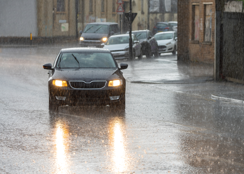 heavy strom cars driving on road
