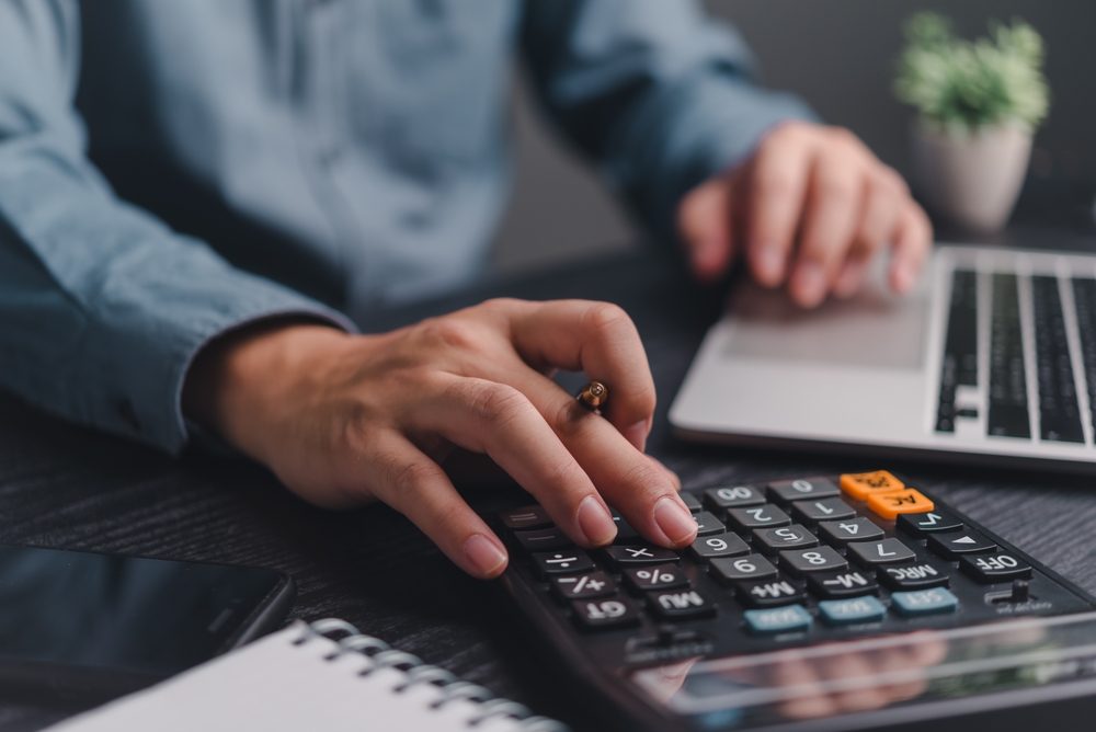 Businessman using calculator bookkeeping payroll and budget tax. Business document finance accounting investment